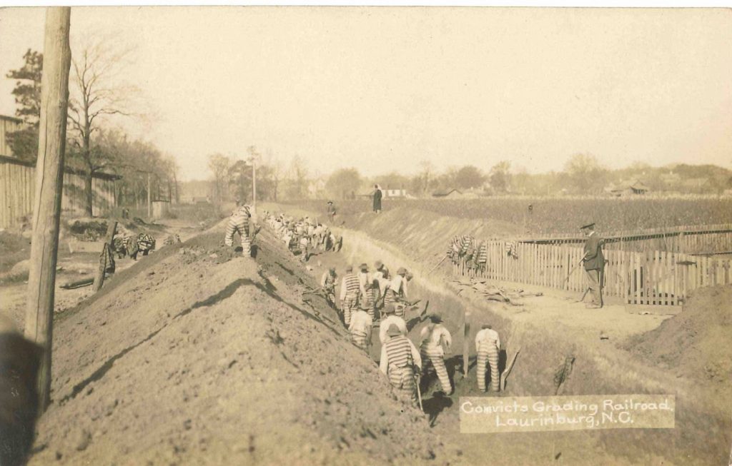 Black and white photograph of prisoners digging railroad trenches